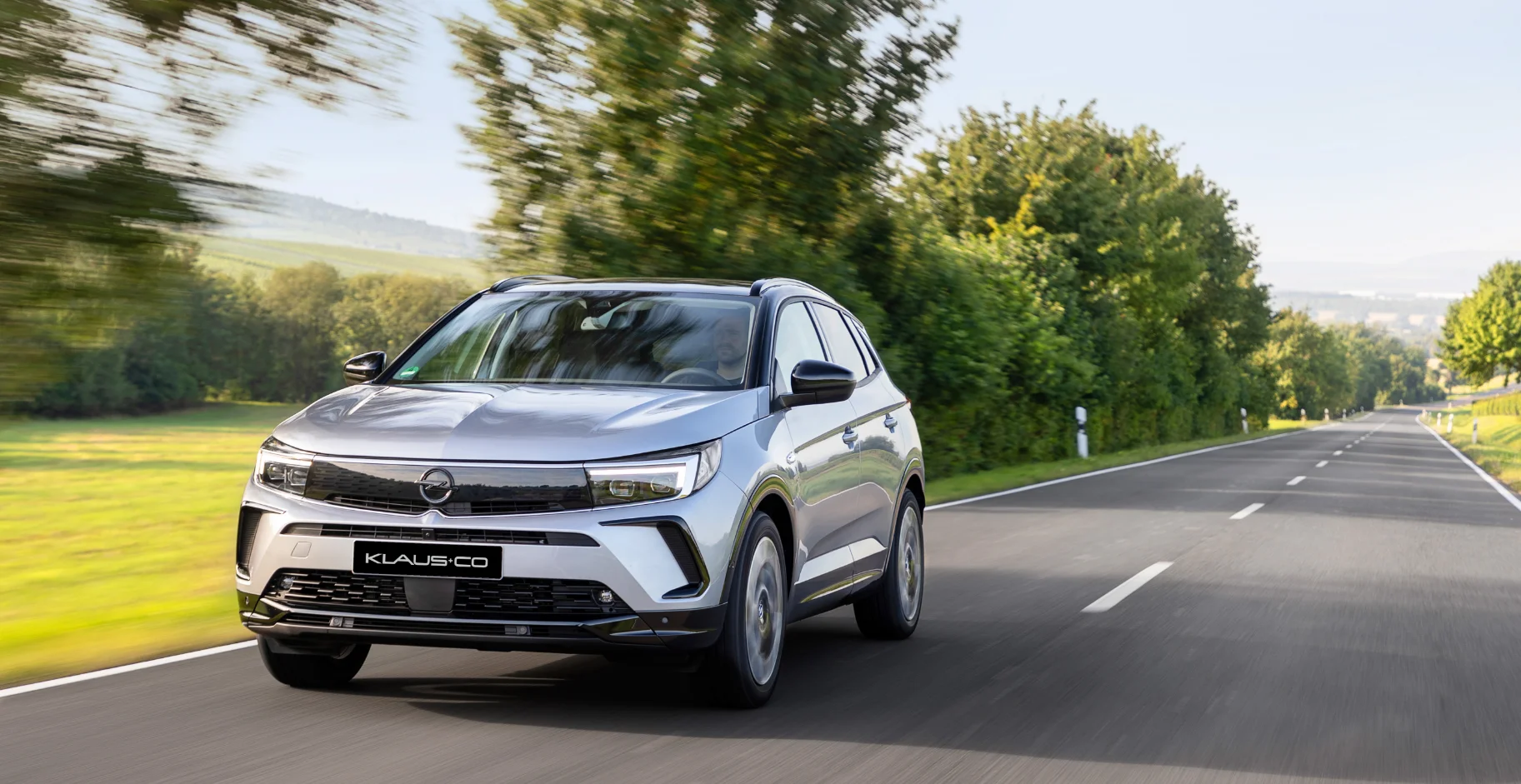 Ein neuer silberner Opel unterwegs auf einer Straße